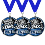 Custom acrylic Father's Day BMX race medals by BML Trophies & Awards. The design includes a BMX rider silhouette, blue neck ribbons, and place designations for first, second, and third place.
