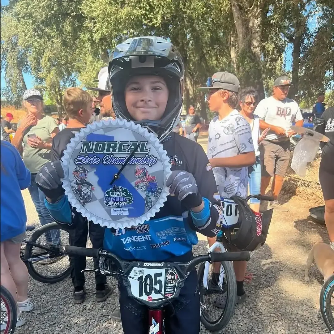 BMX Racer holding a clock award from BML Trophies
